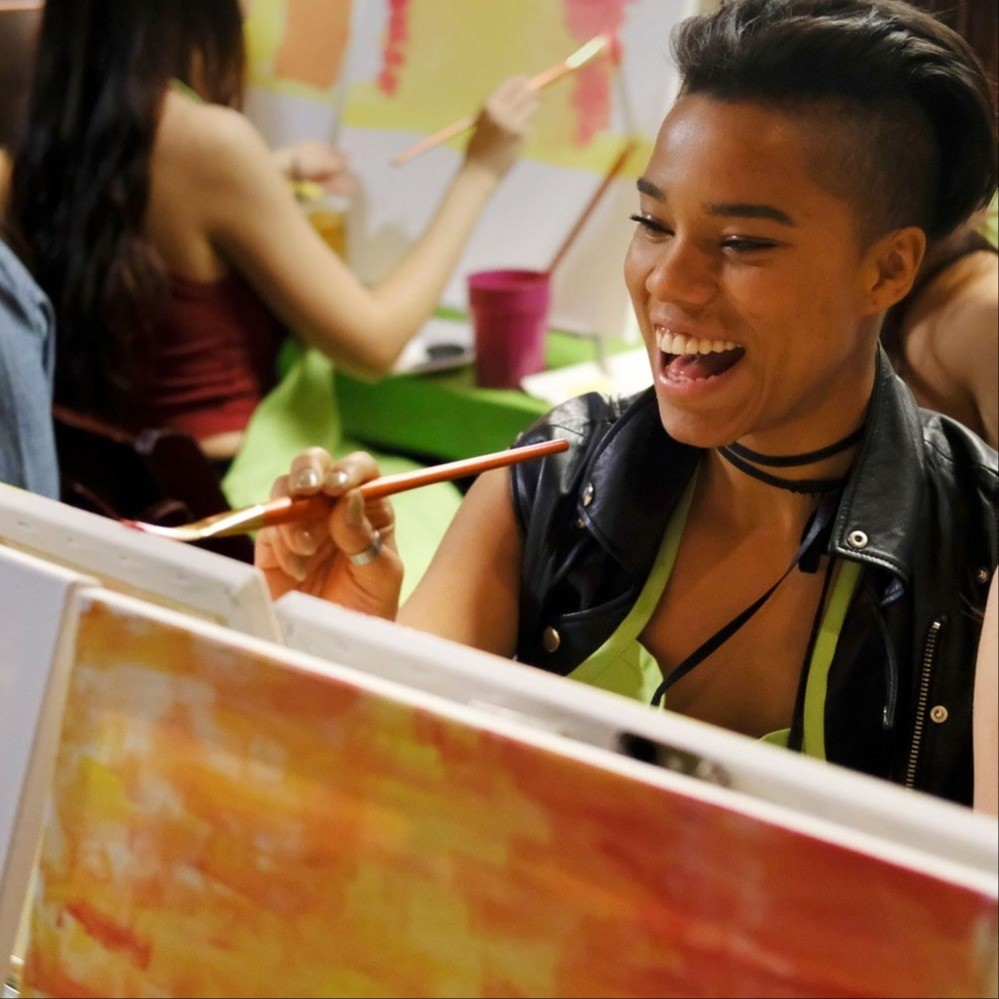 people painting on canvases